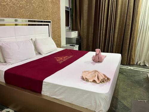 una cama con un osito de peluche rosa sentado en ella en New Abdeen palace hostel en El Cairo