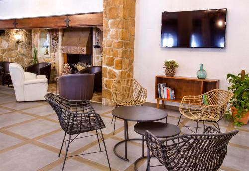 vestíbulo con sillas, mesa y TV en Hotel Ramis, en Ondara