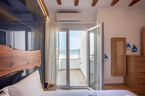 a bedroom with a bed and a door to a balcony at Salty Loft in Hanioti