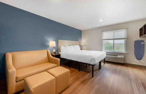 ein Schlafzimmer mit einem Bett, einem Sofa und einem Stuhl in der Unterkunft Extended Stay America Suites - St Paul - Woodbury in Woodbury