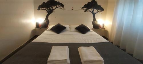 a bedroom with a large bed with two trees on the wall at Street Art Inn Florence in Florence