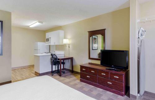 a hotel room with a bed and a tv and a desk at Extended Stay America Select Suites - Fayetteville - Owen Dr in Fayetteville