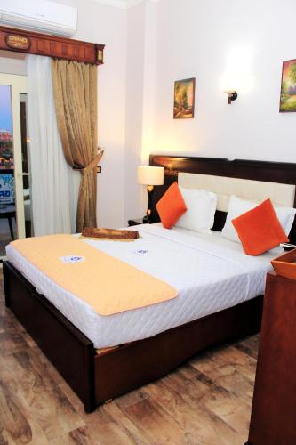 a bedroom with a bed with orange and white pillows at Grand Hotel Ras Elbar in Ras El Bar