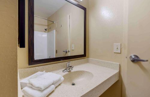 a bathroom with a sink with a mirror and towels at Extended Stay America Select Suites - Fayetteville - Owen Dr in Fayetteville