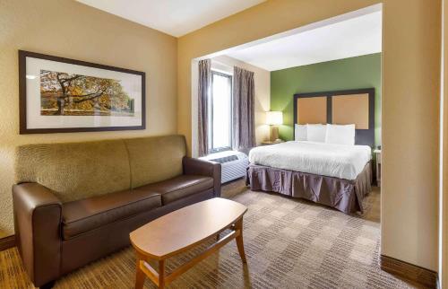 Habitación de hotel con cama y sofá en Extended Stay America Suites - Raleigh - Cary - Regency Parkway South, en Cary