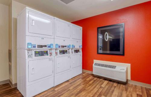 um quarto com armários brancos e uma parede laranja em Extended Stay America Suites - Asheville - Tunnel Rd em Asheville