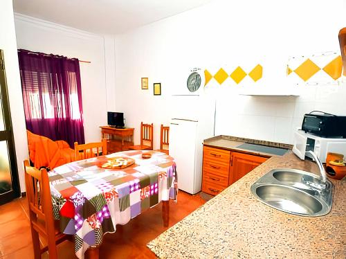 een keuken met een tafel en een wastafel bij Apartamentos Noria Familias y Parejas Gold in Conil de la Frontera