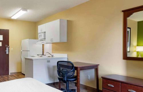 a small kitchen with a desk and a white refrigerator at Extended Stay America Suites - Savannah - Midtown in Savannah