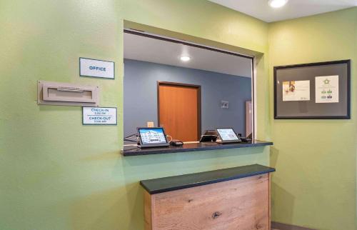 a mirror in a doctors office with two laptops on a counter at Extended Stay America Select Suites - Fort Walton Beach in Fort Walton Beach
