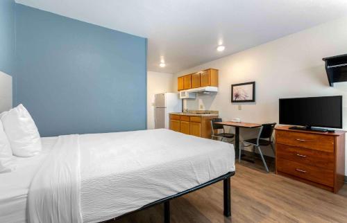 Habitación de hotel con cama y escritorio con TV. en Extended Stay America Select Suites - El Paso - East, en El Paso