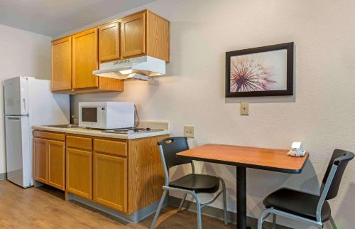 a small kitchen with a table and a refrigerator at Studio 6 Extended Stay El Paso East TX in El Paso