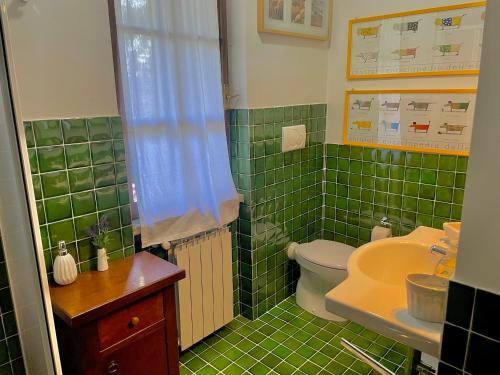 a green tiled bathroom with a toilet and a sink at B&B Notti Serene in Allumiere