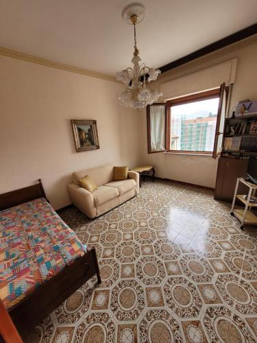 uma grande sala de estar com uma cama e um sofá em Avellino camera 3 letti centralissima em Avellino