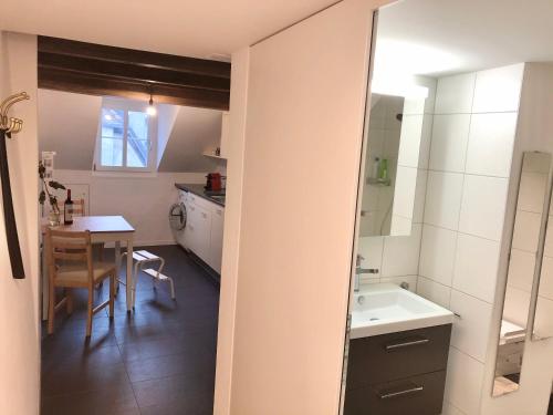 a bathroom with a sink and a table and a mirror at Old Town Apartments in Bern