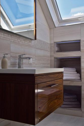 a bathroom with a sink and a mirror at Superior - Ferienhaus am Engelsbach mit Pool im Thüringer Wald in Engelsbach