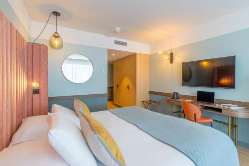 Cette chambre comprend un lit et un bureau. dans l'établissement Golden Tulip Aix les Bains - Hotel & Spa, à Aix-les-Bains