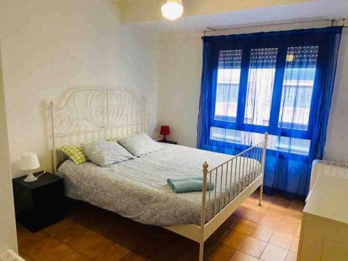 1 dormitorio con cama blanca y ventanas azules en ApartamentoS centro ciudad 2 habitaciones ELDA en Elda