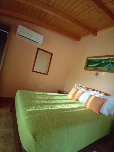 a bedroom with a green bed in a room at Apartamentos na Quinta Altavista do Carvalhal in Zambujeira do Mar