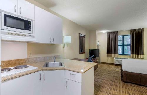 a kitchen with a sink and a room with a bed at Extended Stay America Select Suites - Atlanta - Alpharetta - Rock Mill Rd in Alpharetta