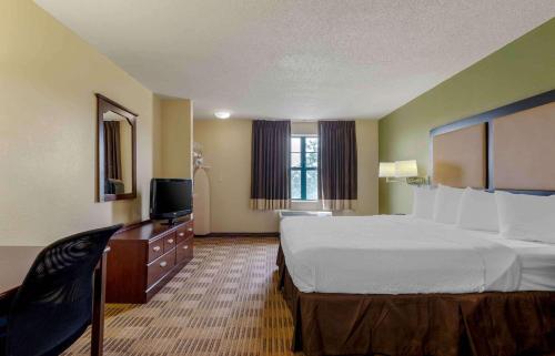 a hotel room with a large bed and a television at Extended Stay America Select Suites - Atlanta - Alpharetta - Rock Mill Rd in Alpharetta