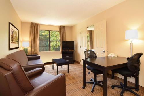 sala de estar con sofá, mesa y escritorio en Extended Stay America Suites - Atlanta - Alpharetta - Northpoint - West, en Alpharetta