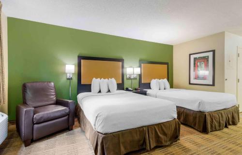 a hotel room with two beds and a chair at Extended Stay America Suites - Atlanta - Marietta - Windy Hill in Atlanta