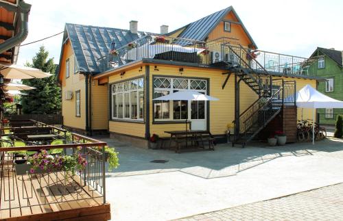 Casa amarilla con mesa y sombrilla en Embrace Hotel & Apartments en Pärnu