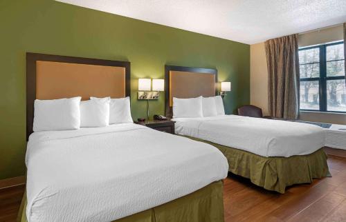 two beds in a hotel room with green walls at Extended Stay America Select Suites - Atlanta - Morrow in Morrow