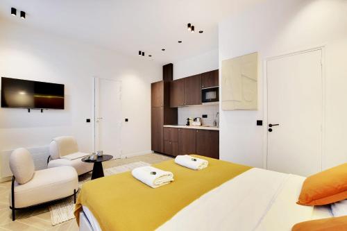 - une chambre avec un lit, une chaise et une télévision dans l'établissement Saint Ambroise COSY SUITE 2P 1BDR, à Paris