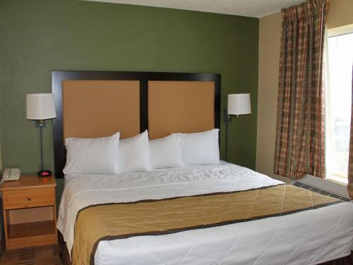 um quarto com uma cama grande e almofadas brancas em Extended Stay America Suites - Newark - Christiana - Wilmington em Rutherford