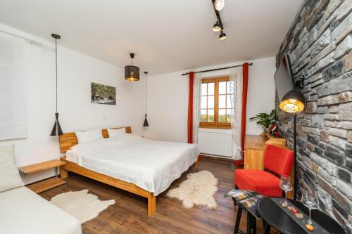 a bedroom with a bed and a brick wall at B&B Villa Sumrak Plitvica Rooms in Plitvička Jezera