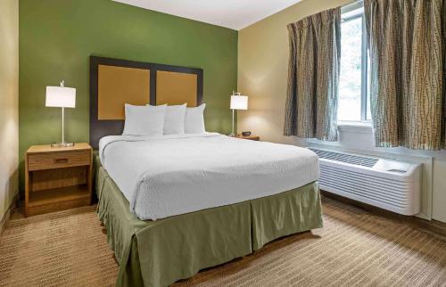 a hotel room with a bed and a window at Extended Stay America Select Suites - Greensboro - Wendover Ave in Greensboro