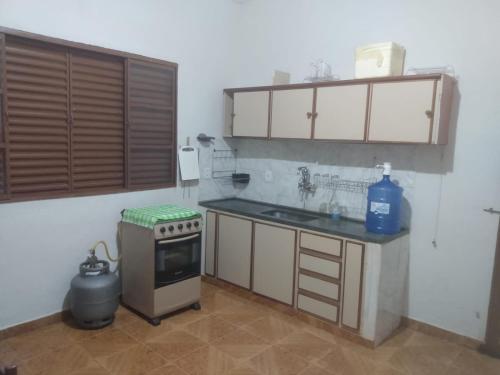 a small kitchen with a sink and a stove at Rancho Belo in São José da Barra