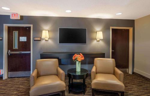 a waiting room with two chairs and a table and a tv at Suburban Studios Exton - Philadelphia Great Valley in Exton