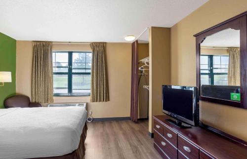 a hotel room with a bed and a flat screen tv at Suburban Studios Exton - Philadelphia Great Valley in Exton
