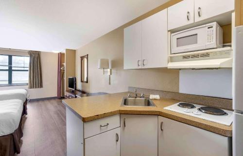 a small kitchen with a sink and a microwave at Suburban Studios Exton - Philadelphia Great Valley in Exton