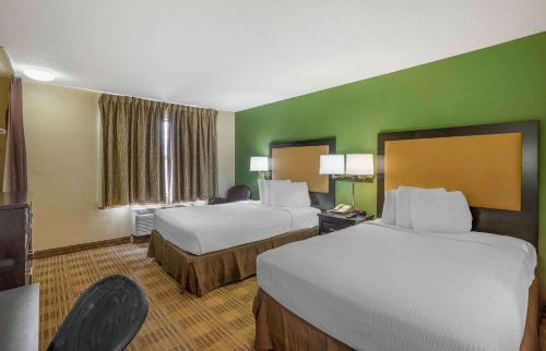 a hotel room with two beds and green walls at Extended Stay America Suites - Philadelphia - Horsham - Welsh Rd in Horsham