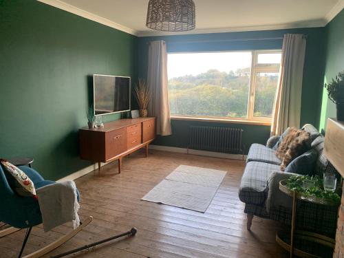 a living room with a tv and a couch and a window at Tenby house for 6 with 2 parking spaces in Pembrokeshire