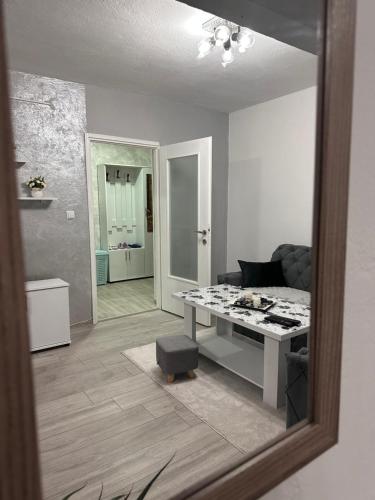 a living room with a table and a mirror at Apartman ALEA in Pale