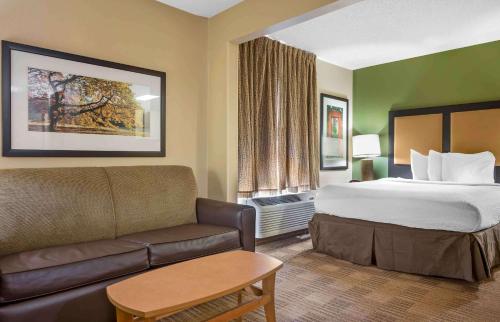 Extended Stay America Suites - Pittsburgh - Airport في Imperial: غرفه فندقيه بسرير واريكه