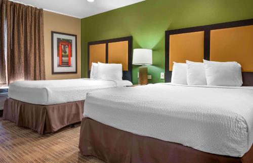 two beds in a hotel room with green walls at Extended Stay America Suites - Pittsburgh - Airport in Imperial