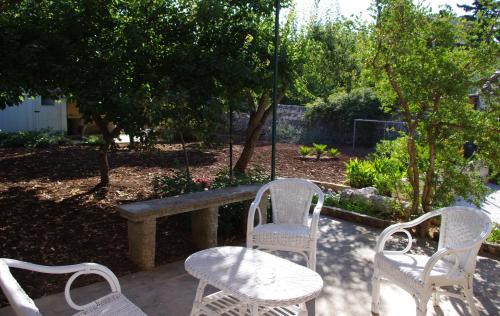 a group of white chairs and tables in a garden at La Piccola Locanda in Modica