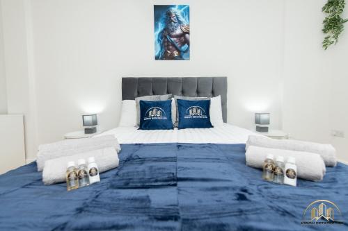 a bedroom with a king sized bed with blue and gold pillows at Zeus Apartment - The Thunder of Town in Southampton