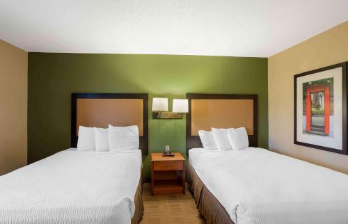 two beds in a hotel room with green walls at Extended Stay America Select Suites - Wilkes - Barre - Scranton in Wilkes-Barre