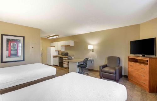 a hotel room with two beds and a flat screen tv at Extended Stay America Select Suites - Wilkes - Barre - Scranton in Wilkes-Barre