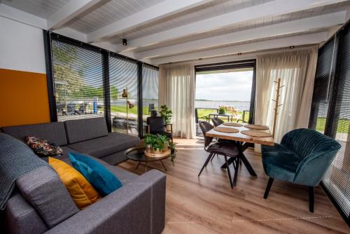a living room with a couch and a table at Vakantiewoonboot De Waterparel in Offingawier