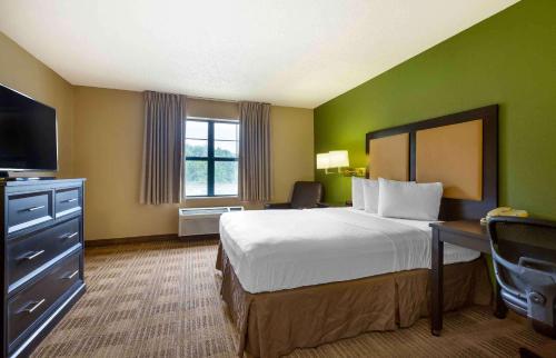 a hotel room with a bed and a flat screen tv at Extended Stay America Suites - Baltimore - Timonium in Timonium