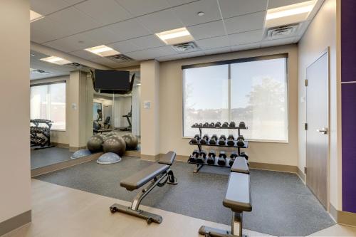 un gimnasio con equipo de ejercicios y una gran ventana en Holiday Inn Express Holly Springs - Raleigh Area, an IHG Hotel en Holly Springs