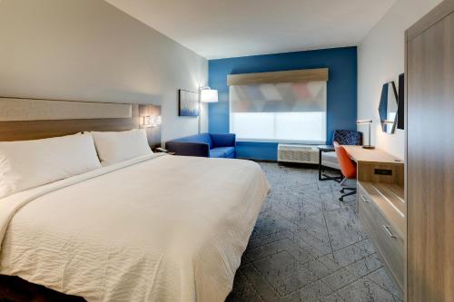 Cette chambre comprend un lit et un bureau. dans l'établissement Holiday Inn Express Holly Springs - Raleigh Area, an IHG Hotel, à Holly Springs