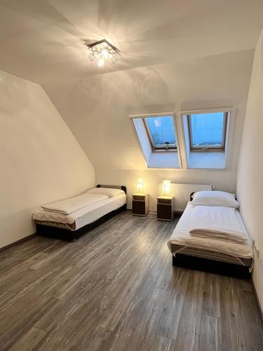 two beds in a room with two windows at Rédiapartmanok in Budapest
